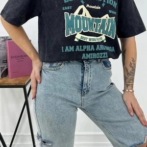 Detail of vintage washed black oversized t-shirt with Mountain graphic and distressed jeans
