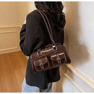 Close-up of a chocolate brown patent leather shoulder bag with silver metallic buckles