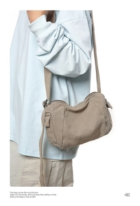Side view of khaki canvas messenger bag with adjustable strap on model showing fit