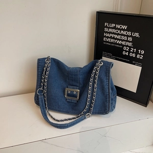 Sac hobo en denim avec boucle argentée et bandoulière chaîne sur table en marbre