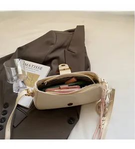 Detailed view of cream leather shoulder bag interior with phone and lipstick storage