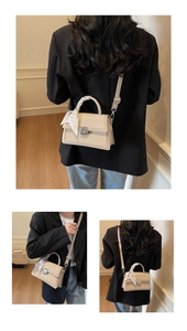 Detail view of beige crossbody bag with silk scarf handle and silver metal clasp