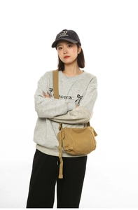 Détail de la bandoulière en toile kaki avec sangle réglable et sweat-shirt décontracté