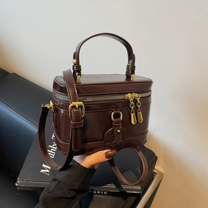 Dunkelbraune Retro-Kosmetiktasche aus Glanzleder mit Griff und goldenen Beschlägen