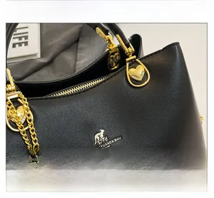 Detailed view of black litchi grain leather and gold heart charm with crystal accents