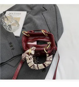 Top view of red leather bucket bag with printed silk scarf handle and spacious interior