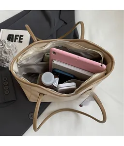 Top view of spacious beige tote bag interior with compartments holding tablet and books