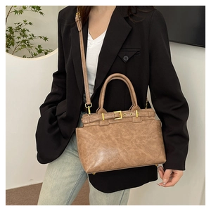 Détails du sac fourre-tout en cuir marron vintage avec boucles dorées et bandoulière
