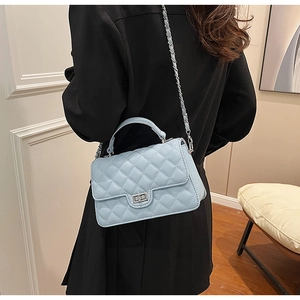 Detailed back view of a light blue quilted chain bag on model in a modern interior