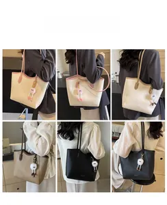 Detail view of large contrast stitching tote bag worn by model in three colors