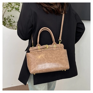 Détails d'un cabas en cuir marron vintage avec boucles dorées et clous de protection
