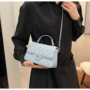 Detail of light blue quilted leather bag with silver twist lock and chain strap