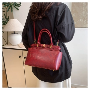Détail du sac fourre-tout vintage rouge foncé avec finitions dorées et bandoulière