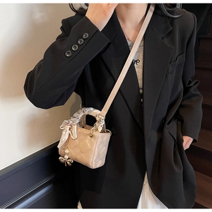 Quilted mini handbag with patterned scarf handle and pearl charm detail view