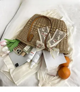 Spacious woven straw beach bag with floral lace ribbon and brown leather circular handles