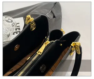 Close-up of premium smooth golden zipper and branded monogram lining of a black handbag