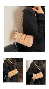 Detail of light brown retro underarm bag with metal buckle and polka dot scarf accessory