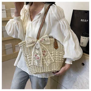 Detail of woven straw tote bag with floral lace bow and premium leather shoulder strap
