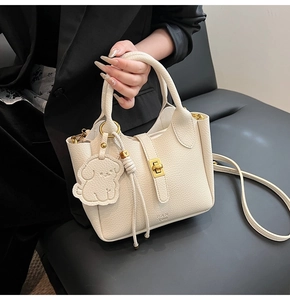 Dettaglio della borsa a secchiello in pelle litchi bianco crema con chiusura in metallo