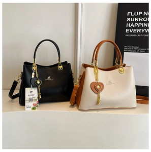 Detailed view of fashion tote bags with gold metal handles and heart charm decorations