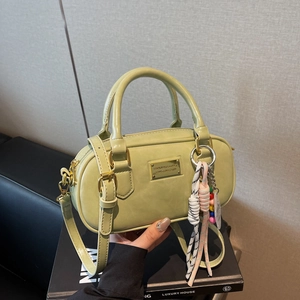 Mintgrüne Bowling-Handtasche mit goldener Logo-Plakette und geflochtenem Anhänger