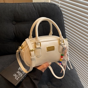 Schicke beige Bowlingtasche aus Kunstleder mit Doppelgriffen und bunten Anhängern