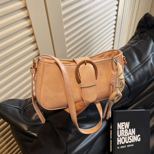 Pink faux leather baguette shoulder bag with metal ring buckle and woven tassel charm