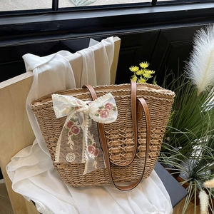 Fashionable woven straw beach tote with white lace flower and brown leather handles