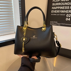 Black leather-style crossbody bag with gold hardware, heart charm and kangaroo logo