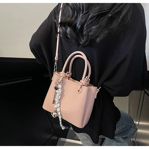 Detailed macro of pink lychee leather texture with decorative ribbon and metal charms