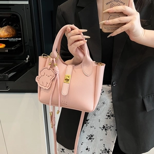 Borsa a secchiello in pelle litchi rosa con chiusura dorata e ciondolo a forma di cane