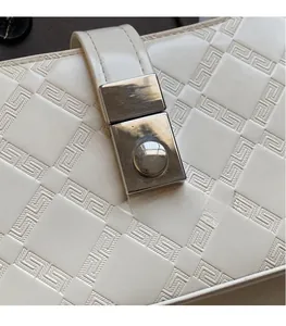 Macro shot of white leather embossed texture and silver rectangular metal lock buckle