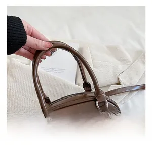 Détail d'un sac à main vintage en cuir marron avec anneau en D argenté et fermeture éclair