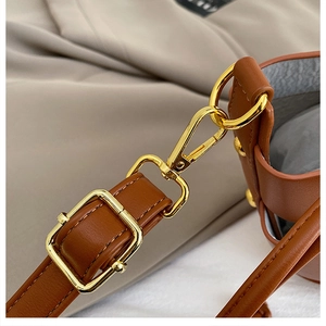 Détails de la ferrure dorée et bandoulière réglable sur sac à main en cuir marron