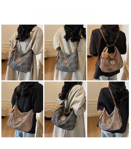 Dettaglio della borsa Hobo grande con logo M, ciondolo a orsetto e nappina sulla modella