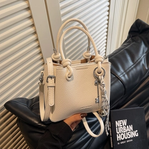 White lychee pattern leather handbag with knot handle and stylish charm accessories