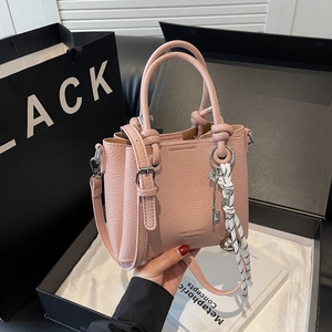 Pink lychee leather crossbody handbag in black gift box with woven charm accessory