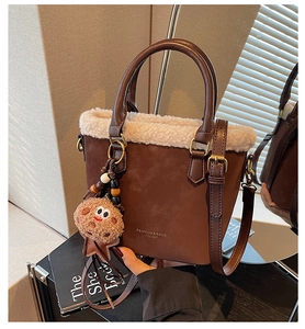 Détail de la bordure en peluche sur le sac seau en daim marron avec pendentif mignon