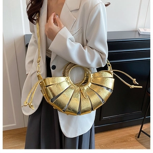 Détail du sac à main doré tissé en éventail avec poignées métalliques et doublure à cordon