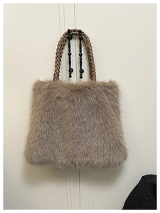 Detail of plush faux fur tote bag with thick woven handles in brown gray tone