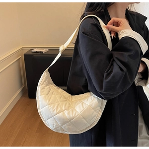 Borsa a tracolla a mezzaluna trapuntata in ecopelle bianco sporco indossata da modella