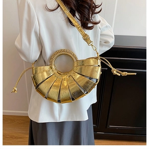 Vue latérale d'un sac à main doré plissé en forme d'éventail porté par un mannequin chic