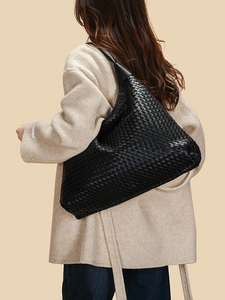 Grand sac cabas en cuir tressé noir pour femme porté par un mannequin en manteau beige