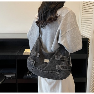 Détails du sac à bandoulière en denim noir délavé avec boucles en métal et plaque logo