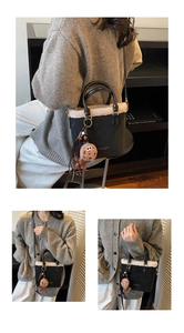 Détail du sac seau en daim noir avec bordure en peluche blanche et breloque petit biscuit