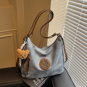 Borsa tote in tela grigia con manici in pelle marrone e ciondolo a forma di orsetto