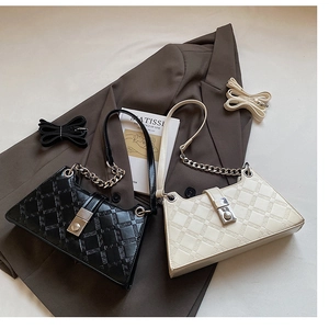 Detail of black and beige shoulder bags with geometric texture and metal chain straps