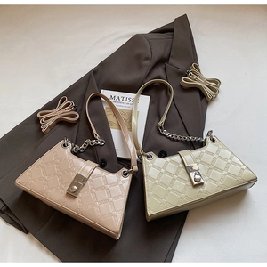 Detail view of pink and beige underarm bags with embossed patterns and metal chain straps