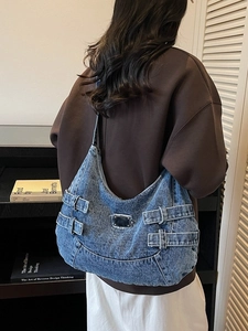 Sac hobo en denim délavé rétro avec boucles réglables porté dans un décor vintage chic