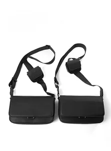 Detail of two black Saffiano PU leather crossbody bags with adjustable straps and coin pouches